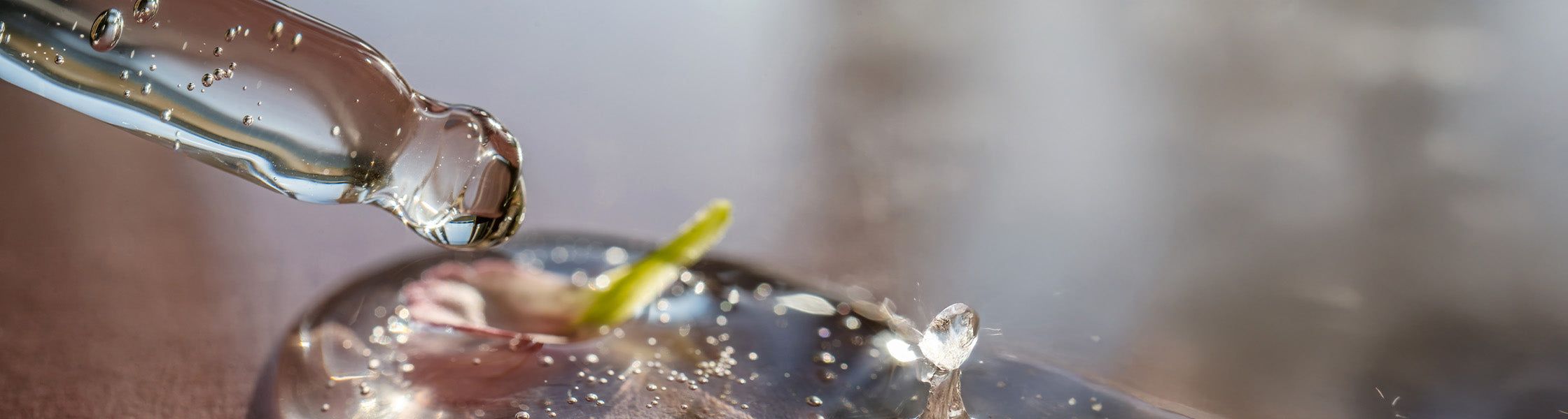 Nahaufnahme einer Pipette mit flüssigem Kräuterextrakt, tropfend auf einer Oberfläche