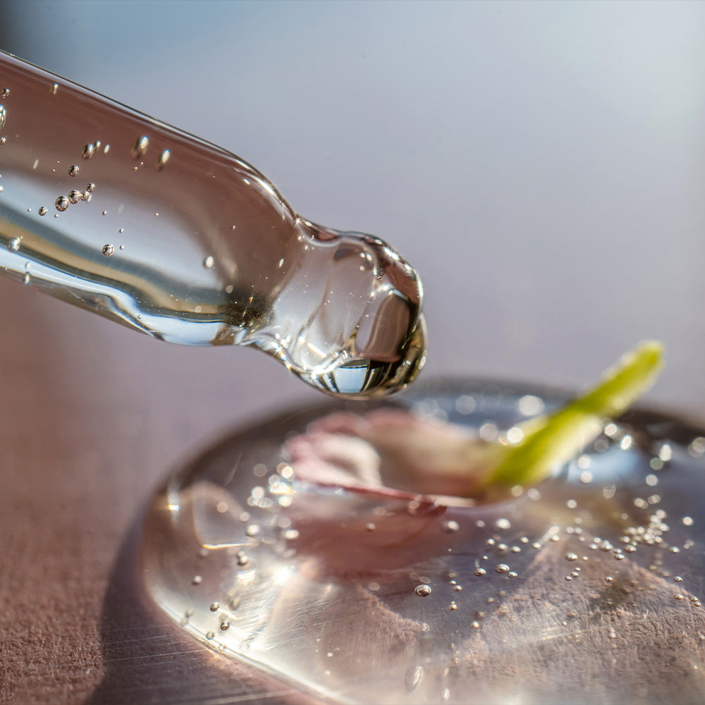 Pipette mit transparentem Kräuterextrakt, der auf eine Oberfläche tropft